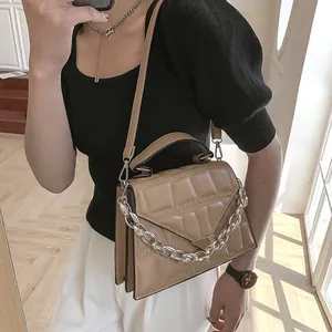 Close-up of khaki quilted crossbody bag featuring a thick silver chain handle and metal detail