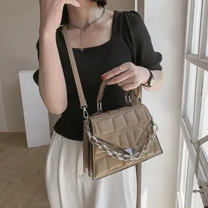 Quilted khaki crossbody bag with silver chain detail and metallic triangle clasp