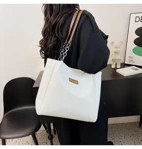Dettaglio della borsa shopper bianca trapuntata con tracolla in pelle e catena