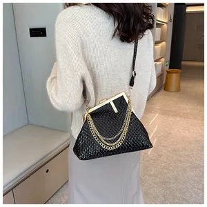 Detailansicht der schwarzen Prägeledertasche mit goldenem F-Verschluss und Goldketten