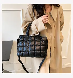 Detail view of black quilted down tote bag with a smooth finish and sturdy handles