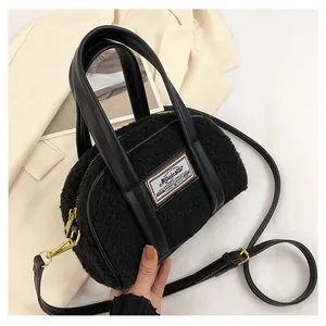 Close-up of black plush lamb-like crossbody bag with adjustable strap and metal zipper