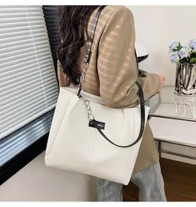 Dettaglio della borsa shopper bianca trapuntata con manici neri e catena d'argento
