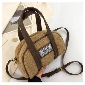 Detail of the camel lamb wool texture with brown leather strap and golden hardware