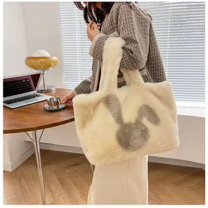 Detail of a large off-white plush tote bag with rabbit print shown on a shoulder