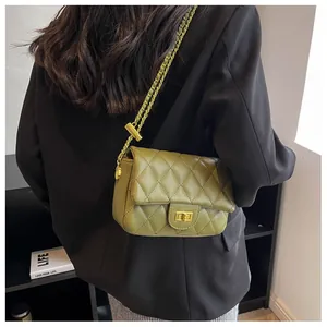 Avocado green quilted crossbody bag with gold chain strap shown on black blazer