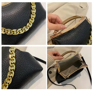 Detailoverzicht van zwarte leren tas met steenstructuur, gouden ketting en sluiting