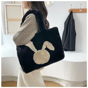 Detail of a large black plush tote bag with a beige cartoon rabbit head on the front