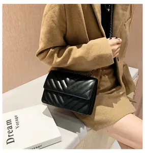 Detail of black V-quilted faux leather bag with matching black metal chain strap