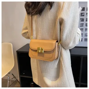 Detail shot of khaki shoulder bag featuring croc-effect texture and gold buckle