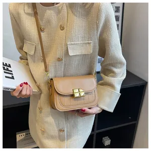 Detail of khaki leather crossbody bag with crocodile texture and gold geometric buckle