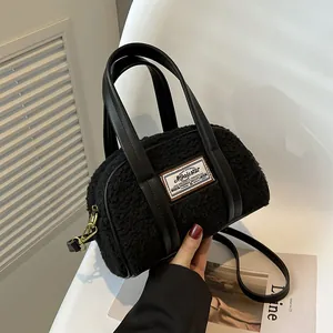 Chic black faux fur mini Boston bag with plush texture and leather handles for autumn winter