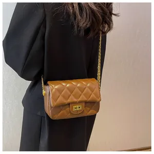 Detail of a brown quilted leather crossbody bag with gold metal chain and twist lock
