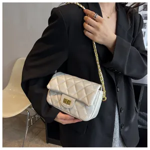 Detailed view of the white quilted leather bag featuring a gold chain strap and square lock
