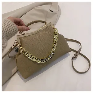 Detail van kaki schelptas met steenpatroon en gouden metalen ketting en sluiting