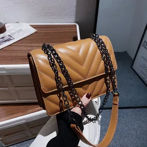 Brown V-quilted faux leather crossbody bag with a black metal chain strap and flap closure