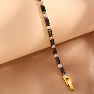 Gros plan d'un bracelet doré avec des pierres de zircone cubique noires et blanches