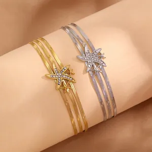Détail macro du bracelet à trois couches avec charm étoile de mer serti de strass brillants