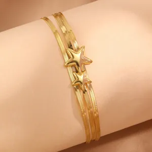 Vue détaillée du bracelet triple rangée en chaîne serpent dorée avec breloques étoiles