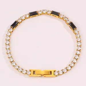 Détail du bracelet en acier doré avec des zircons étincelants et des pierres noires rectangulaires