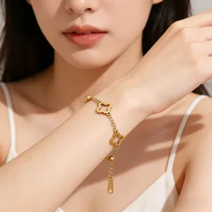 Detailed close-up of a golden clover bracelet with beads and adjustable chain on a wrist