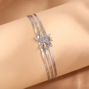 Vue détaillée du bracelet triple chaîne serpent argentée avec des étoiles de mer serties