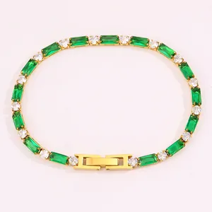 Gros plan du bracelet tennis doré avec zircons verts émeraude et blancs brillants