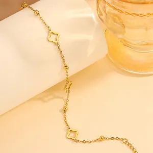 Minimalist gold stainless steel bracelet featuring clover charms and small round beads