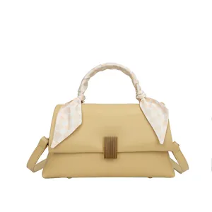 Sac à main beige minimaliste avec boucle dorée et foulard en soie sur la poignée