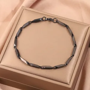 Détail d'un bracelet à maillons noirs avec fermoir mousqueton dans son écrin cadeau