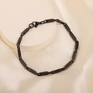 Gros plan sur un bracelet en acier inoxydable noir mat avec maillons facettés et fermoir