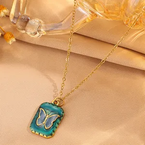 Vintage 18k gold plated butterfly pendant necklace on soft beige silk background