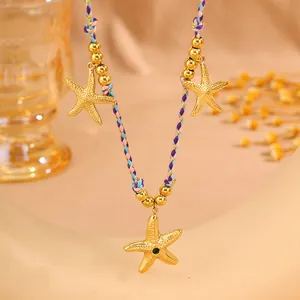 Détail d'un collier bohème tissé avec trois pendentifs étoile de mer dorés et perles
