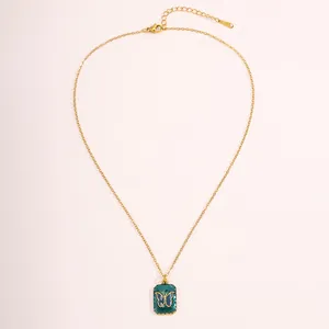 Detail view of a vintage 18k gold plated butterfly pendant necklace with green enamel