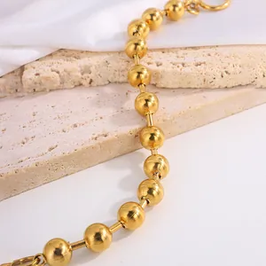 Polished 18k gold stainless steel bead bracelet on elegant neutral background