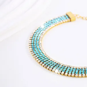 Dettaglio choker dorato a 4 file con pietre di zircone blu e bianche e catena regolabile
