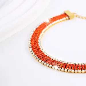 Dettaglio del bracciale in acciaio al titanio a quattro file con strass arancioni e bianchi