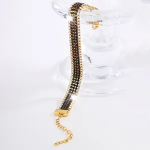 Dettaglio del bracciale in titanio dorato con pietre nere e cristalli incastonati