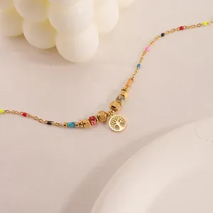 Goldenes Lebensbaum-Armband mit bunten Perlen auf einem eleganten weißen Display