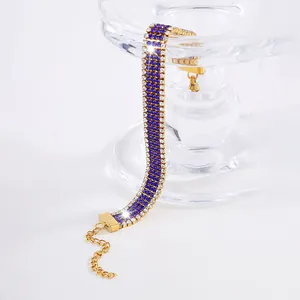 Dettaglio del bracciale dorato a tre file con cristalli blu scuro e trasparenti
