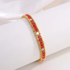 Détail du bracelet en titane doré serti de cristaux rouges et blancs sur satin blanc