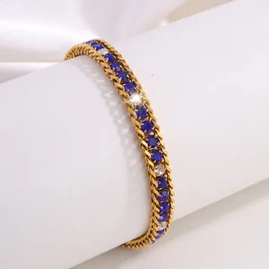 Détail macro du bracelet en acier doré avec cristaux bleus et blancs incrustés