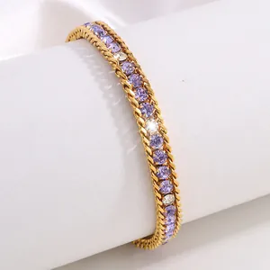 Gros plan d'un bracelet doré orné de strass violets clairs et blancs étincelants
