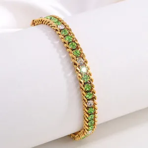 Détail d'un bracelet à double chaîne dorée avec strass verts et blancs scintillants