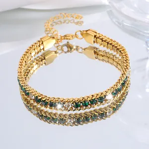 Détail d'un bracelet doré en acier titane serti de pierres vertes et de zircons brillants