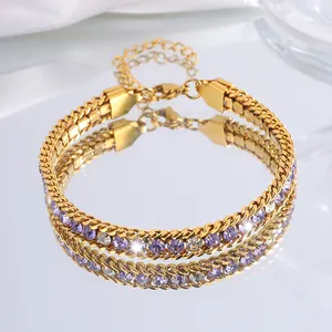 Gros plan du bracelet doré avec cristaux violets et blancs et fermoir mousqueton