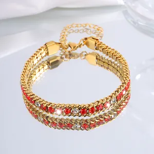 Détail du bracelet chaîne en titane doré avec strass rouges et clairs et fermoir mousqueton