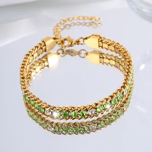 Vue macro d'un bracelet doré avec cristaux verts et blancs et fermoir mousqueton réglable