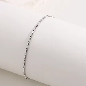 Detailed close-up of a silver stainless steel leaf charm bracelet on a white stand