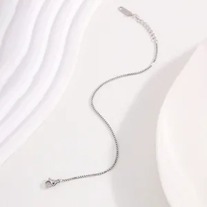 Detailed view of silver stainless steel box chain with leaf charm and lobster clasp